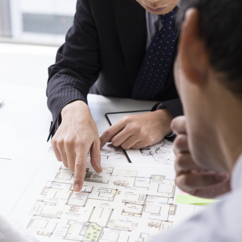 Person pointing at a physical floor plan map