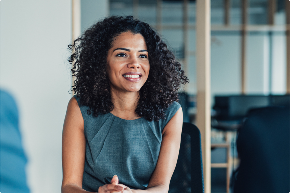 Black woman in professional clothes sitting at a meeting table