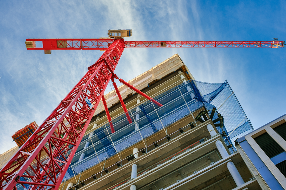 Red crane on construction site for tall building